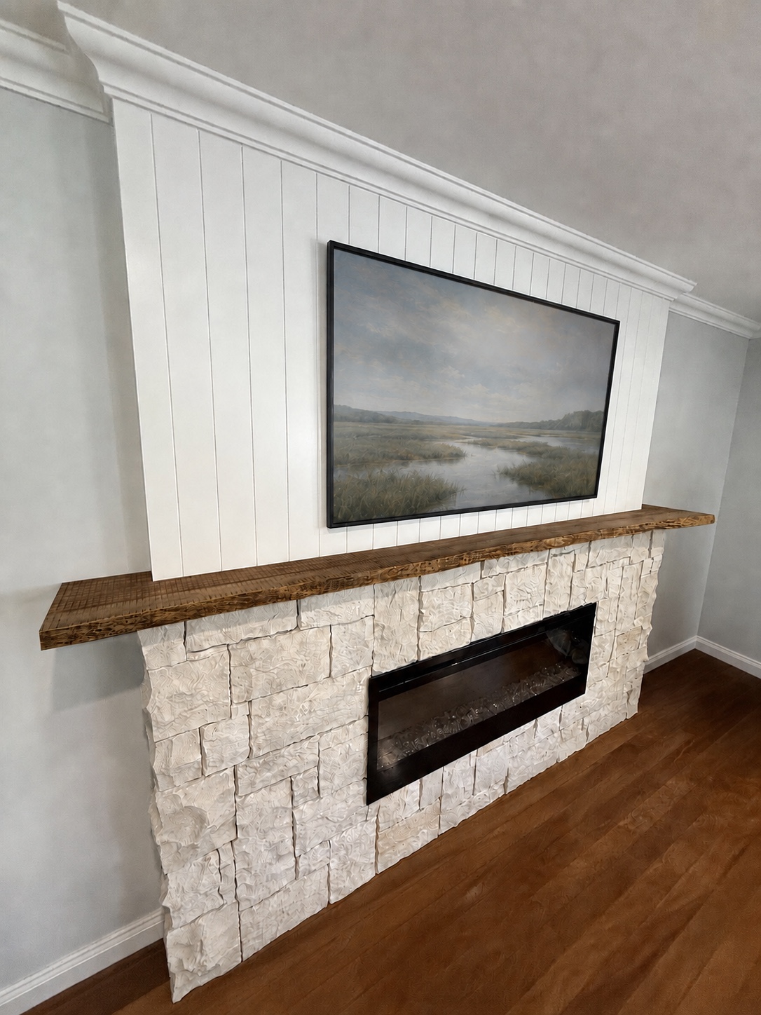 Custom fireplace feature with white dry-stack stonework, vertical VJ panelling, a black firebox and a locally made solid-timber mantel